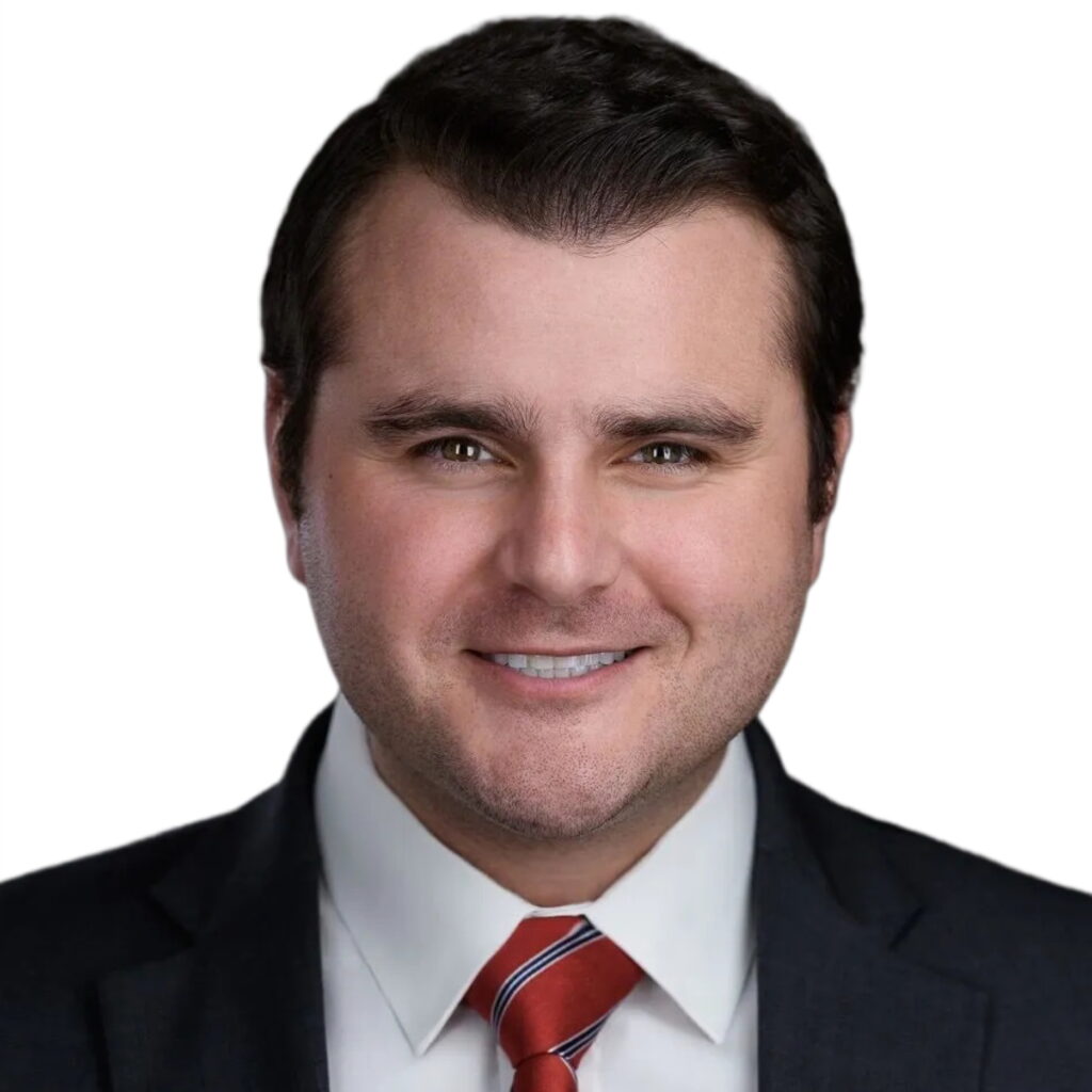 Professional headshot of Gramm J. Klein, Texas personal injury attorney, in suit and red striped tie against white background